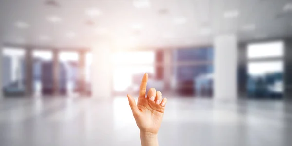 Close of woman hand touching screen with finger in elegant modern interior