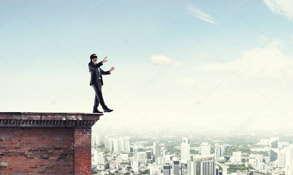 blindfolded Businessman walking on building top
