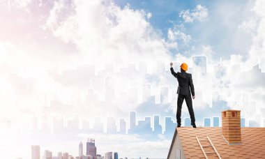 Mühendis adam evin çatısında ayakta 