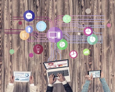 Ellerinde cihazlar bulunan üç kişilik bir grup iletişim ve ağ oluşturma sembolü olarak birlikte çalışıyor.