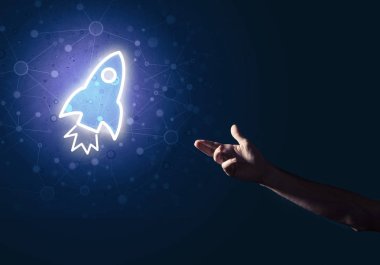 Koyu arkaplanda parlayan roket simgesi ve insan eli