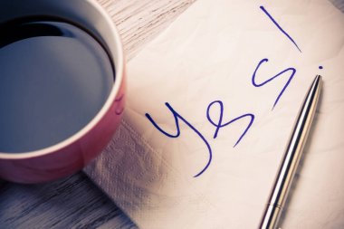 Fincan kahve ve peçete ahşap masa üzerinde mesaj ile