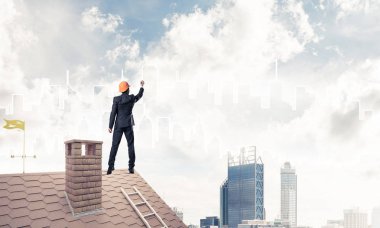 Mühendis adam evin çatısında ayakta 