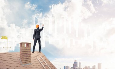 Mühendis adam evin çatısında ayakta 