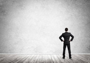 Boş beton odada kendine güvenen zarif iş adamının arka planı