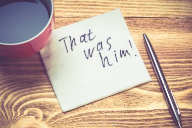 Kahve fincanı, kalem ve kelime ahşap masa üstünde peçeteyle