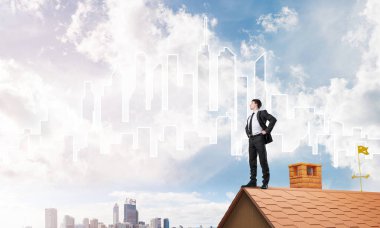 evin çatısında duran işadamı 