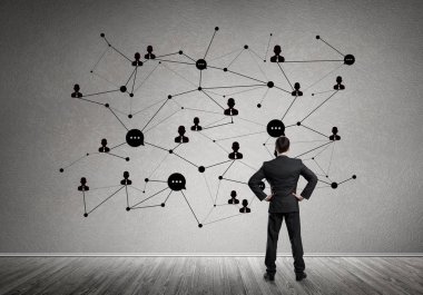 Arkadan görünüşü çizilmiş sosyal bağlantı kavramı ile duvara bakarak işadamı