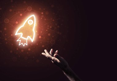 Koyu arkaplanda parlayan roket simgesi ve insan eli