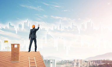 Mühendis adam evin çatısında ayakta 