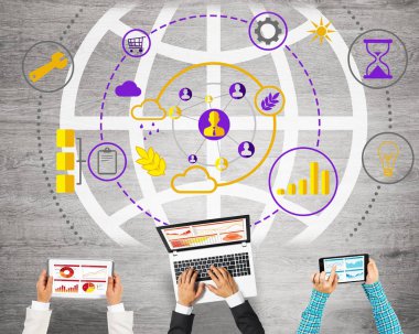 Ellerinde cihazlar bulunan üç kişilik bir grup iletişim ve ağ oluşturma sembolü olarak birlikte çalışıyor.