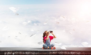 Dürbünle bakan, okul çağındaki sevimli kız çatıyı inşa ediyor.