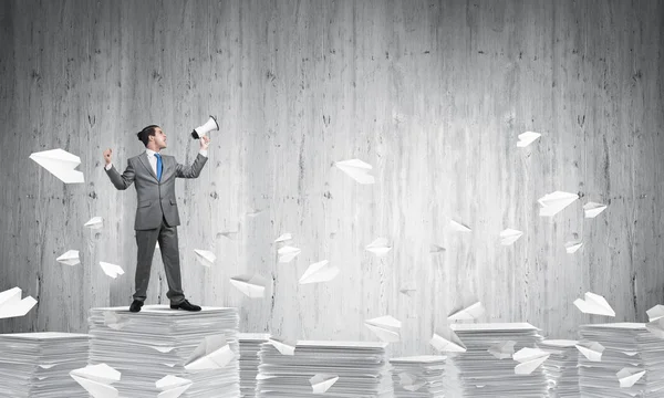 Businessman Suit Standing Flying Paper Planes Speaker Hand Grey Wall — Stock Photo, Image