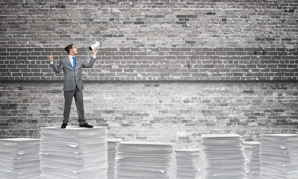 Businessman in suit standing on pile of documents — Stock Photo, Image