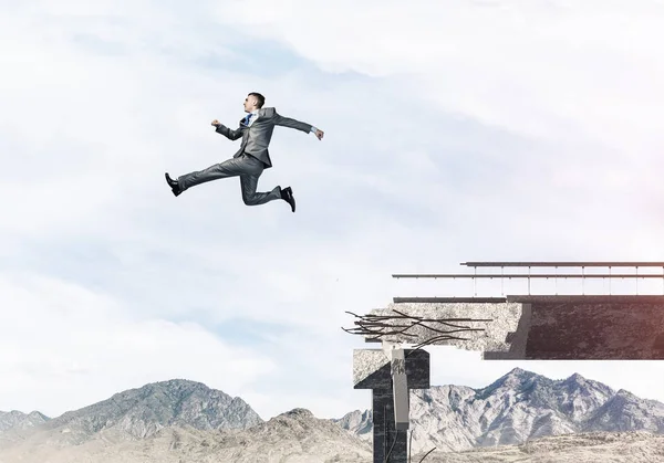 Empresario saltando sobre enorme brecha — Foto de Stock