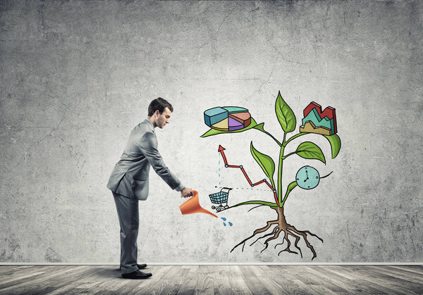 Handsome businessman watering drawn growth concept with can 