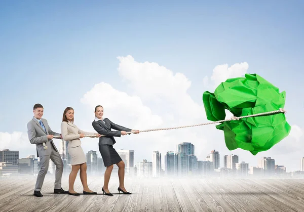 employees pulling together paper ball