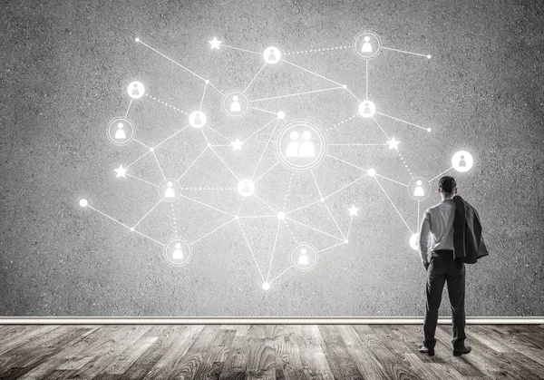Arkadan görünüşü çizilmiş sosyal bağlantı kavramı ile duvara bakarak işadamı