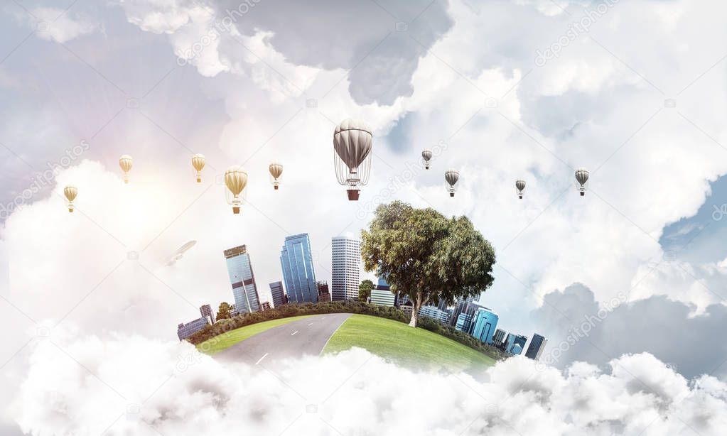 Green flying island with urban view of towers and skyscrapers. Flying aerostates and blue cloudy skyscape on background. 