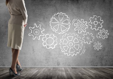 Duvarın önünde çekilmiş vites mekanizması, ekip çalışması kavramı ile ayakta işkadını alttan görünüm 