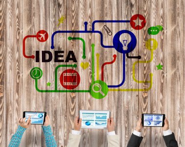 Ellerinde cihazlar bulunan üç kişilik bir grup iletişim ve ağ oluşturma sembolü olarak birlikte çalışıyor.