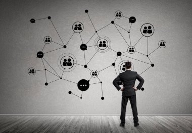 Arkadan görünüşü çizilmiş sosyal bağlantı kavramı ile duvara bakarak işadamı