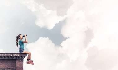 Dürbünle bakan, okul çağındaki sevimli kız çatıyı inşa ediyor.