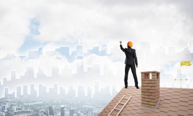 Mühendis adam evin çatısında ayakta 