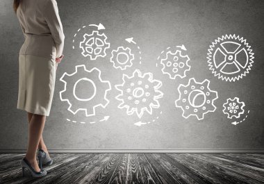 Duvarın önünde çekilmiş vites mekanizması, ekip çalışması kavramı ile ayakta işkadını alttan görünüm 