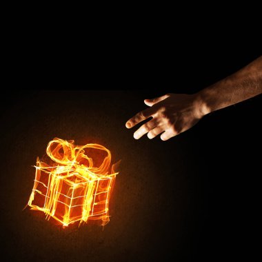 Parlayan yangın hediye kutusu simgesini avuç içi koyu arka plan