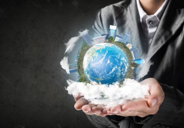 İşadamı dünya küre ile binalar, gri duvar arka plan üzerinde elinde tutan takım elbiseli closeup.