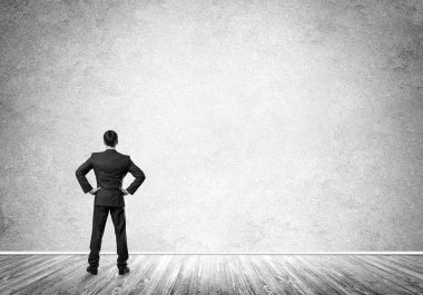 Boş beton odada kendine güvenen zarif iş adamının arka planı