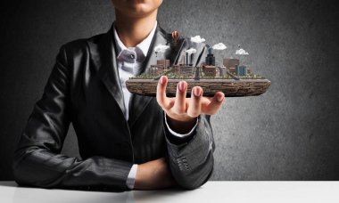 Takım elbise ile arka planda gri duvar onun el modern şehir bloğundaki sunulmasına işadamı Resim kırpılmış. 