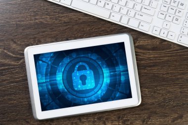 Ahşap masa üzerinde güvenli ödeme konseptiyle tablet