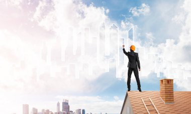 Mühendis adam evin çatısında ayakta 