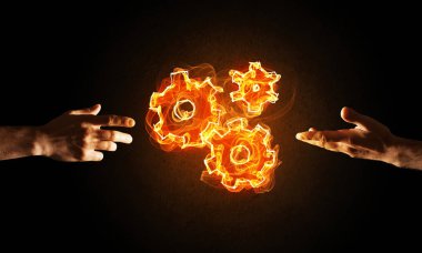 El ateş dişli mekanizması koyu arka plan üzerinde sunulması iş adamı