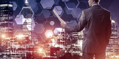 Arka ayakta ve sözleşme veya rapor gece cityscape arka planı elinde tutan işadamı 