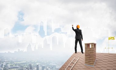 Mühendis adam evin çatısında ayakta 