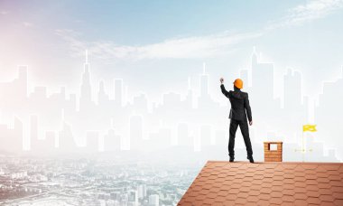 Mühendis adam evin çatısında ayakta 