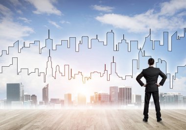 İşadamı arkasını dönüp modern iş merkezinin siluetine bakıyor.