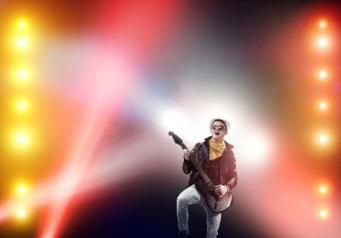 Sahne ışıkları gitar ile rock müzisyeni genç adam