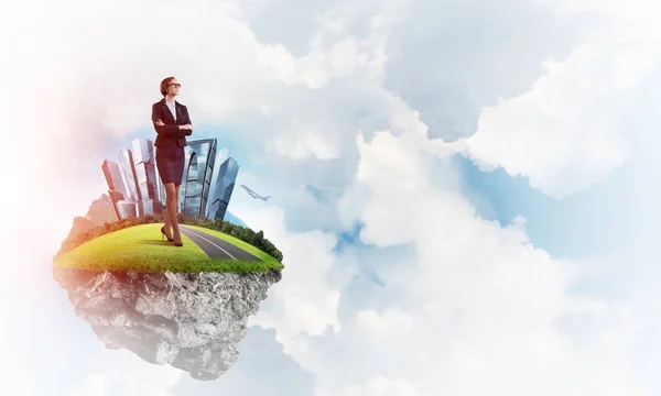 Businesswoman standing on green floating island — Stock Photo, Image