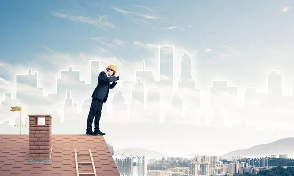 Ung affärsman i kostym och hjälm på taket — Stockfoto