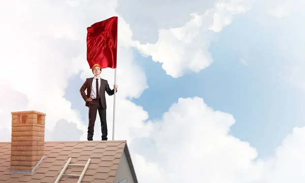 Hombre de negocios de pie en el techo de casa — Foto de Stock