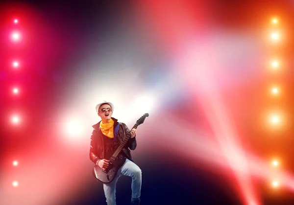 若者は ステージのライトでギターの石の音楽家 — ストック写真