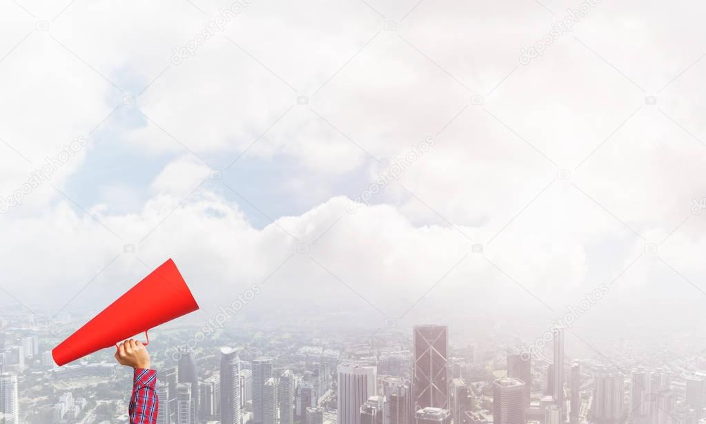 Close of woman making announcement in paper trumpet