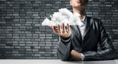 Close-Up iş kadını kıyafetli beyaz bulut el ile karanlık tuğla duvar arka plan üzerinde sunulması.