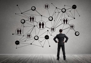 Arkadan görünüşü çizilmiş sosyal bağlantı kavramı ile duvara bakarak işadamı