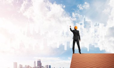 Mühendis adam evin çatısında ayakta 