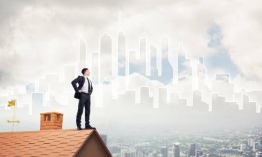 evin çatısında duran işadamı 